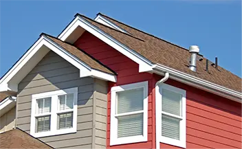 A red and gray suburban house with white trim and a gabled roof